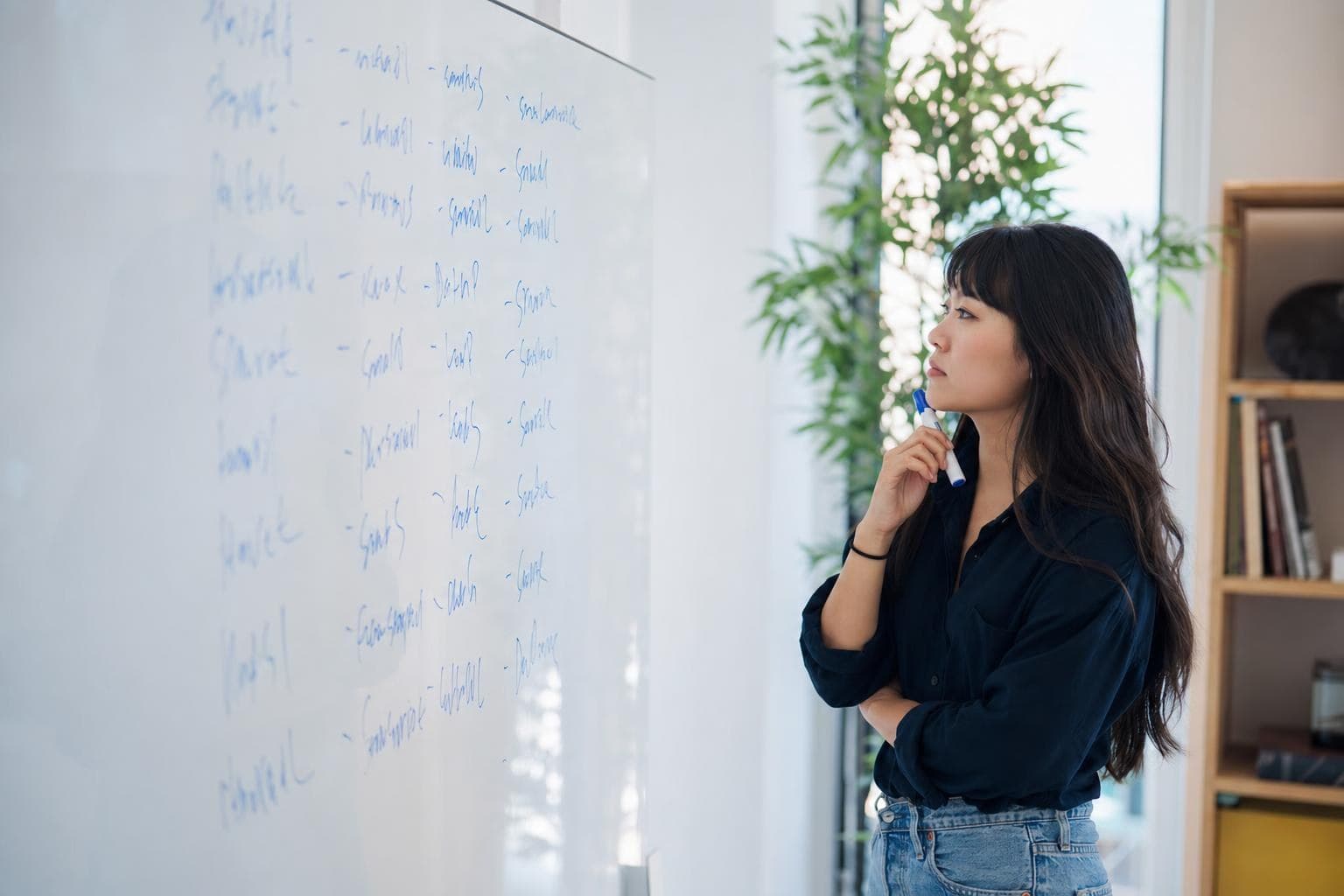 A photo of an owner brainstorming names on a whiteboard covered in candidate words.