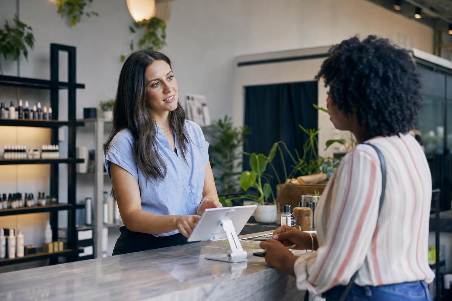 A photo of a confident business owner calmly discussing pricing with a customer across a counter.