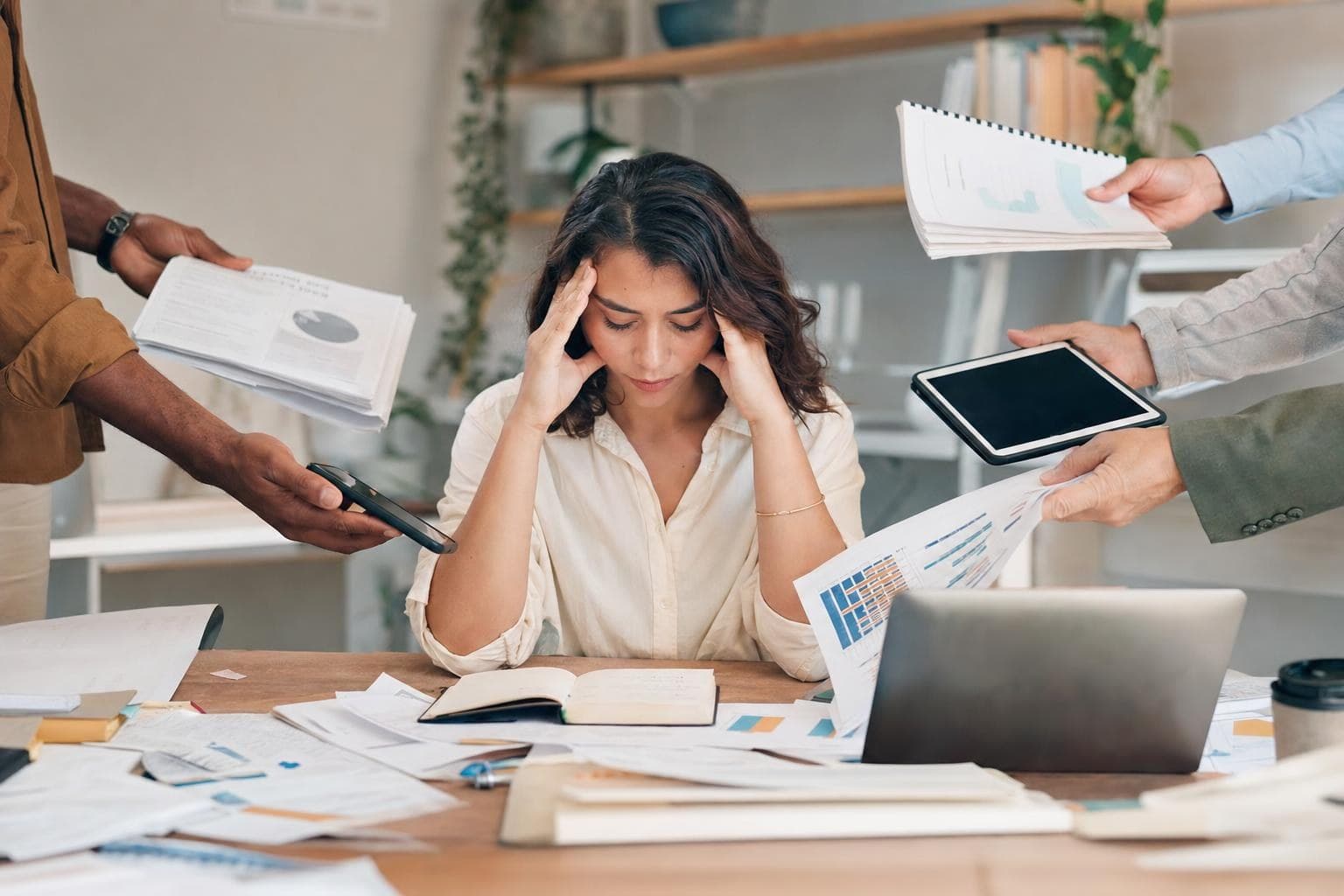 A photo of a small-business owner looking overwhelmed as papers and tasks pile toward their desk, with everything routing to them.