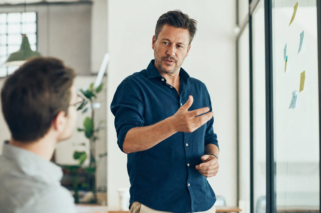 A consultant explaining a plan at a whiteboard