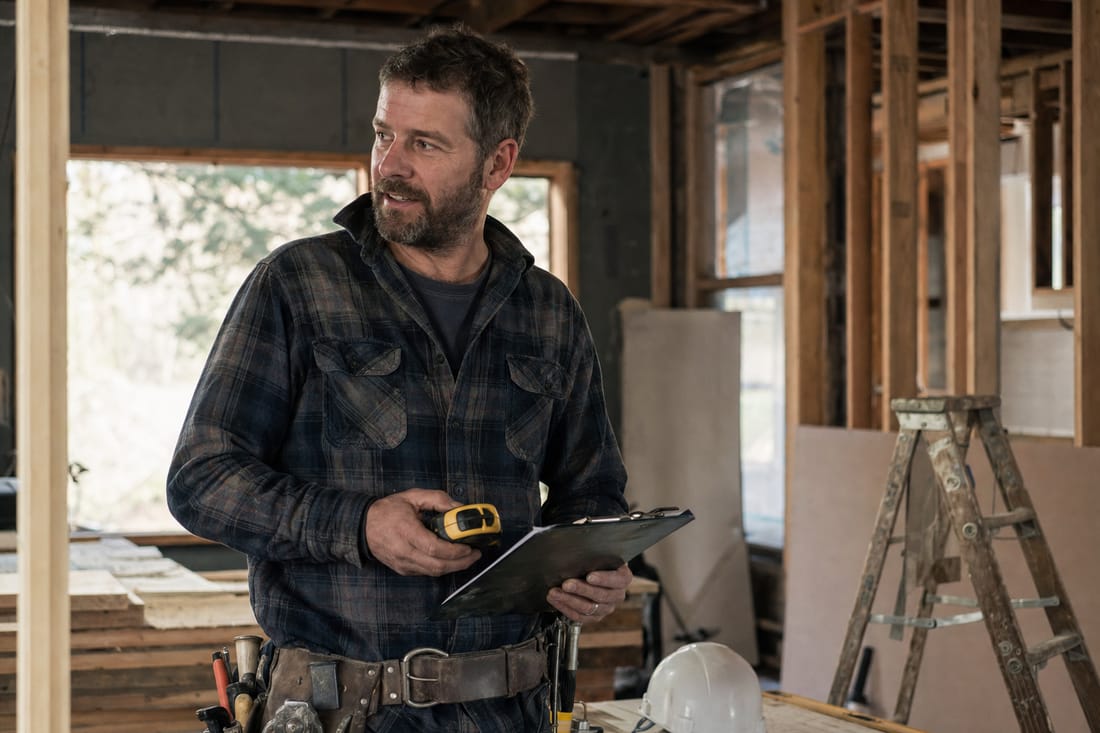 A contractor with a clipboard on a job site