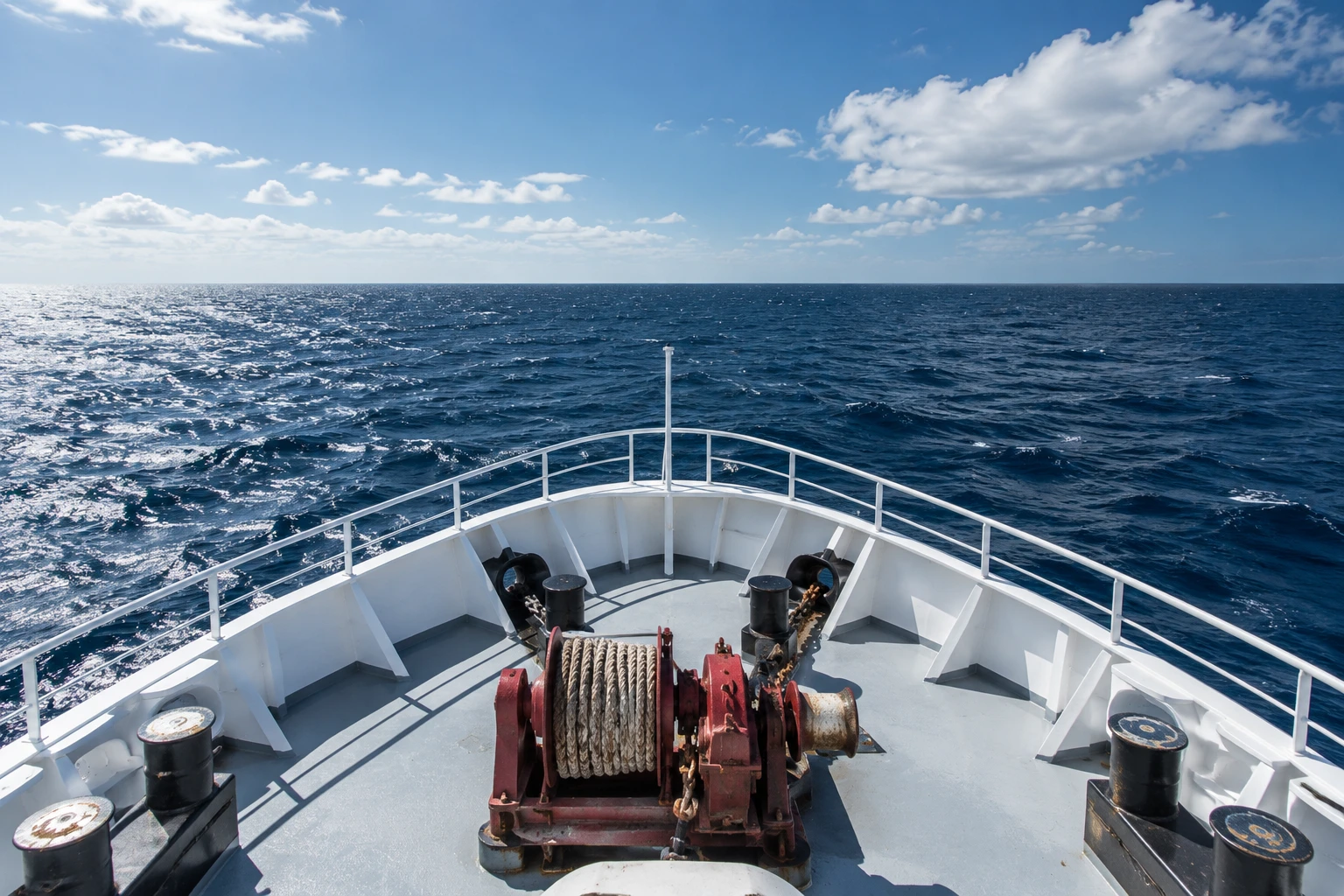An elevated view over a vessel bow toward open water.