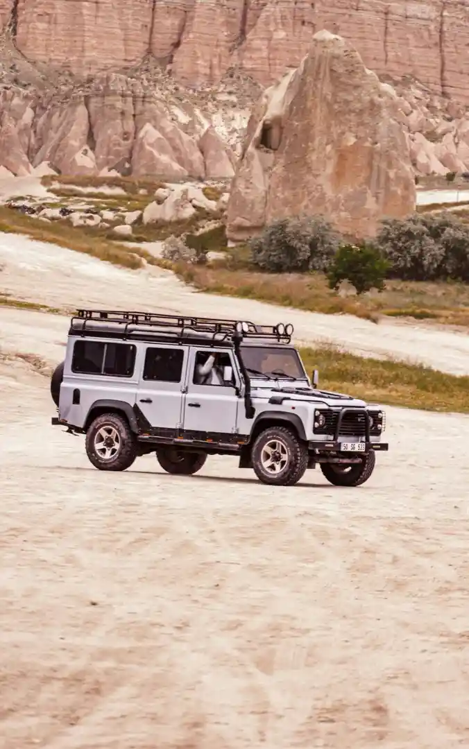 A four-wheel drive in moonlight with rooftop tent set up