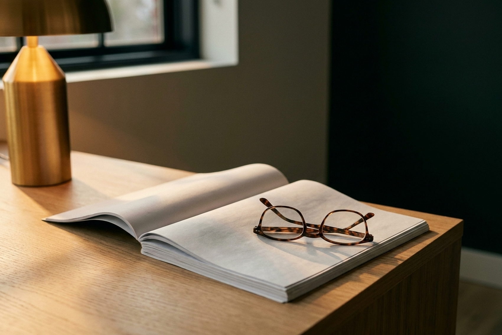 A contract and reading glasses under a desk lamp
